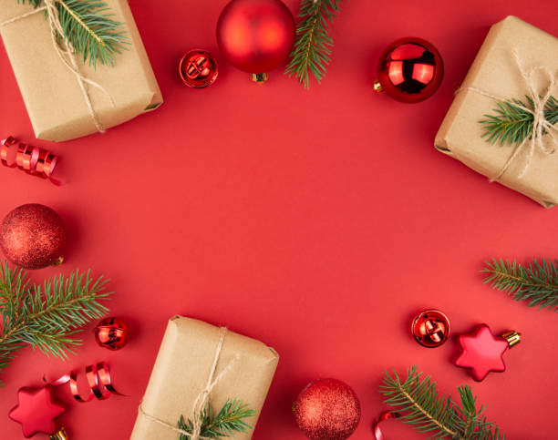 istock New Year's background from gift boxes, Christmas tree branches, red balls, streamers on a red background. Christmas background. Layout of a banner, postcard. The apartment was lying. Copy space 1438737415