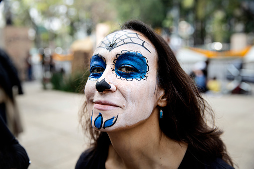 An attractive 40 something woman having her face painted at the annual Day of the Dead parade that takes place every year in late October in Mexico City every year.
Día de los Muertos, or Day of the Dead, is one of Mexico's most recognized holidays. The celebration from Oct. 31 to Nov. 2 commemorates death as an essential element of life and honours loved ones who have passed away.