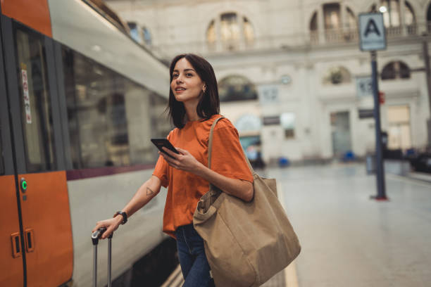 istock A young beautiful Spanish woman is using a mobile phone at a train station while waiting to enter a train car 1438741657