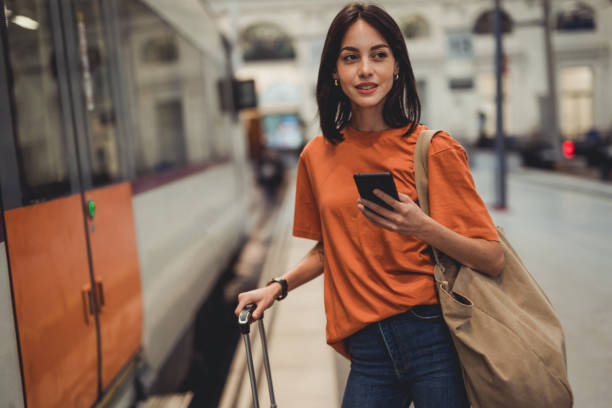 istock A young beautiful Spanish woman is using a mobile phone at a train station while waiting to enter a train car 1438741680
