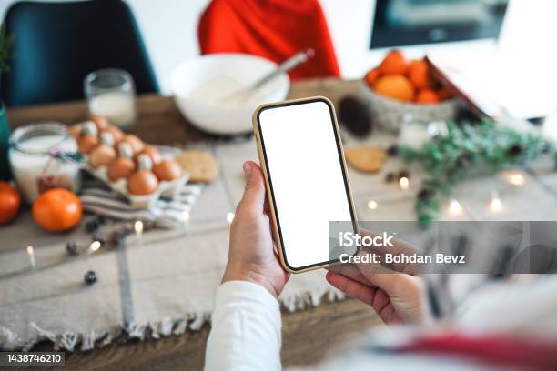 Phone With A Blank Screen In The Hands On The Background Of Christmas Cooking Place For Text Master Class Invitation Merry Christmas Stock Photo - Download Image Now