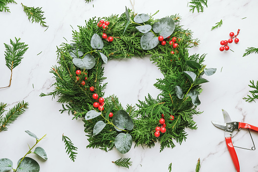 Circular evergreen Christmas wreath. DIY Xmas home decoration.