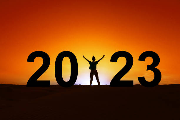 2023, silhouette of a woman standing in the sunrise, women new year greeting card stock photo