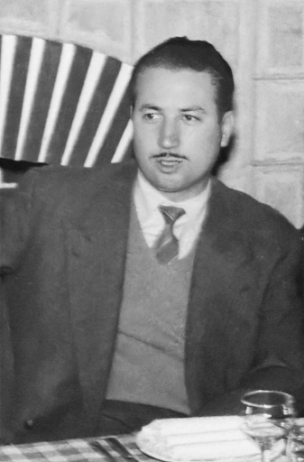 Black and white Image taken in the 50s: Mid adult man sitting at a restaurant table looking away