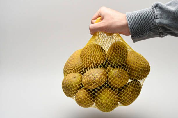 istock Potatoes, a hand holding potatoes in a shopping bag 1438755204