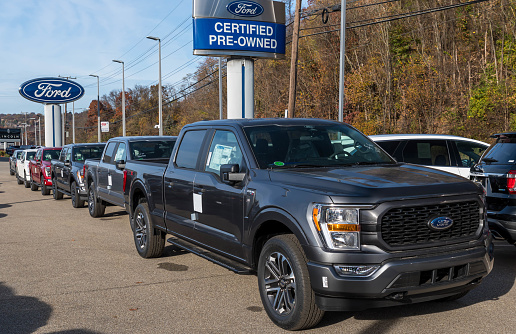 Monroeville, Pennsylvania, USA October 30, 2022 A line of Ford F 150 pick up trucks for sale at a dealership on a sunny fall day