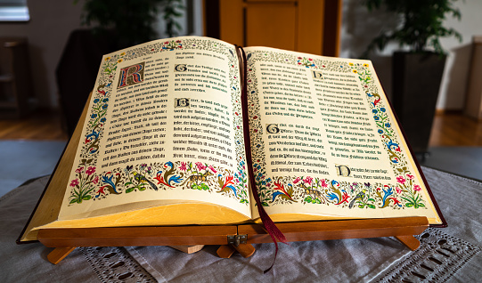 Embrach, Switzerland - October 23, 2022: An open Bible book on a table in the evangelical-reformed church in Embrach.