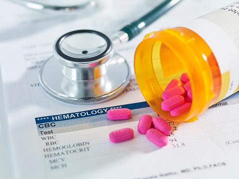 pill box and stethoscope on a medical report