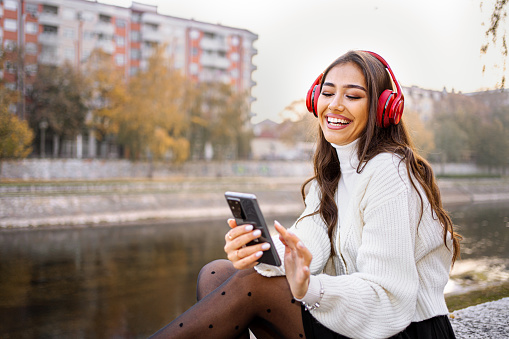 Beautiful young woman relaxing near river in the city park