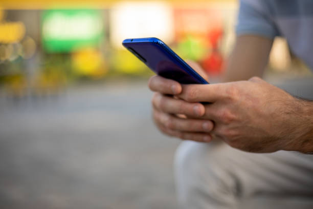 istock Unrecognizable man holding mobile phone in hand, blurred background 1438763972