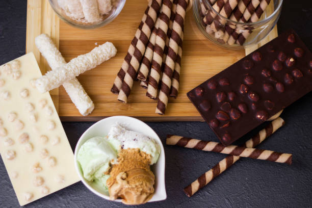 Ice cream with a variety of flavors and sweet toppings Ice cream with a variety of flavors and sweet toppings on a black background ice cream with wafer rolls stock pictures, royalty-free photos & images