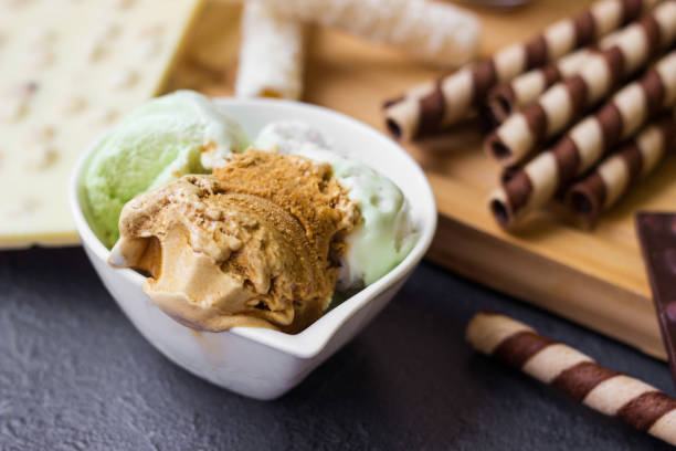 Ice cream with a variety of flavors and sweet toppings Ice cream with a variety of flavors and sweet toppings on a black background ice cream with wafer rolls stock pictures, royalty-free photos & images