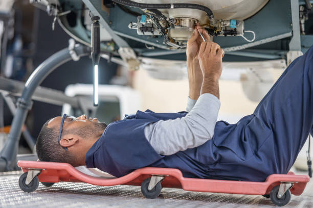 istock African American engineer lying on movable chair and fixing helicopter engine with instrument 1438774033