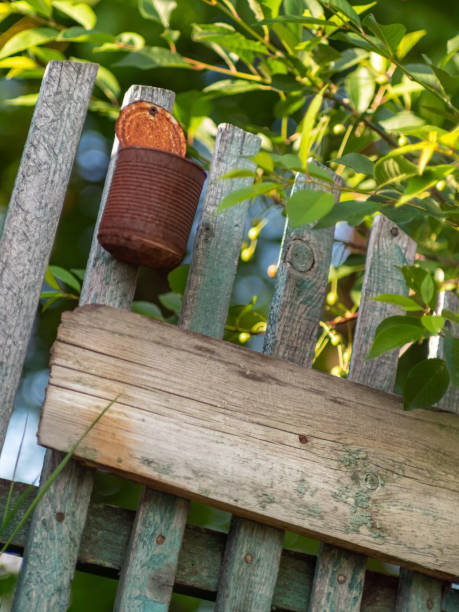 modello originale di una vecchia recinzione di legno rustica con vernice scrostata con copy-space. una latta arrugginita vuota che imita una cassetta postale. dunshifting e concetto di eremo. primo piano con messa a fuoco selettiva - old plank outdoors selective focus foto e immagini stock