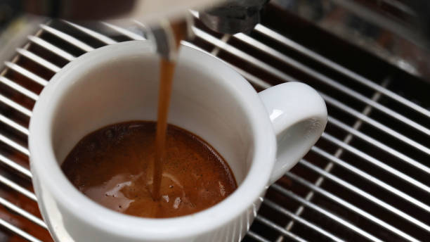 istock Close up of coffee espresso shot being extracted into a small white cup 1438780955