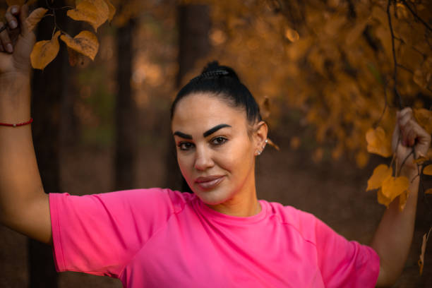 istock Young woman posing while holding branches with a beautiful yellow leaf 1438782230