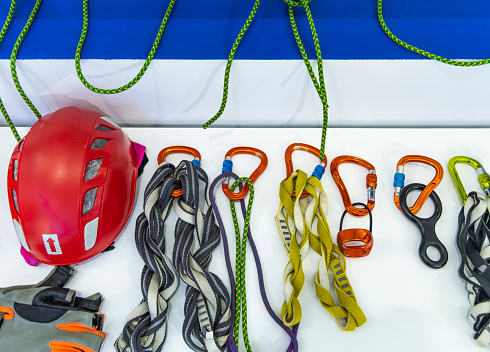 Close up shot of a man's hands operating a rock climbing belaying device.