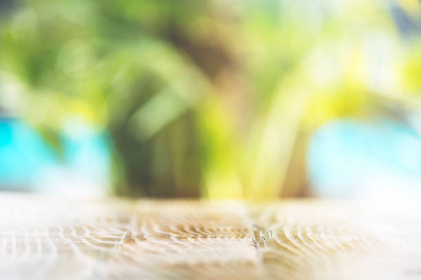 Abstract blurred green color naturL outdoor background at spring and summer season with wooden table on the ground. sunlight effected