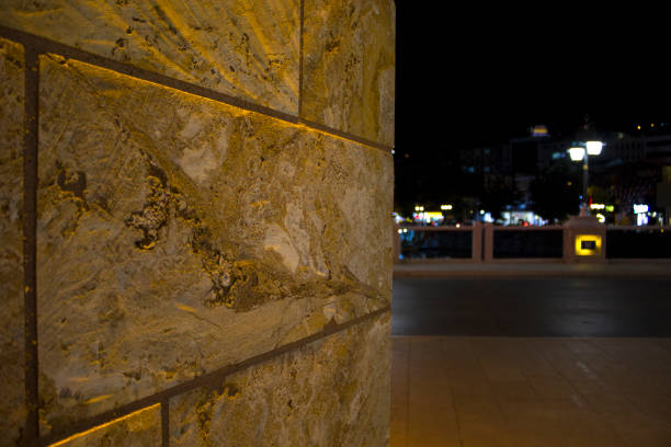 istock Close-up stone wall surface at night. Empty road in the background 1438786814