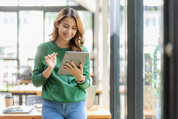 erfolgreiche asiatische geschäftsfrau, die zu hause mit einem tablet arbeitet. surfen im internet social media abspielen kreative planungsarbeit - langstreckenlauf stock-fotos und bilder