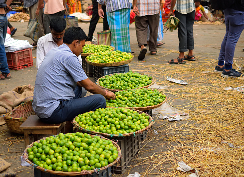 Kolkata, India - March 26, 2017: A street vendor selling basket full of lemons in the market.