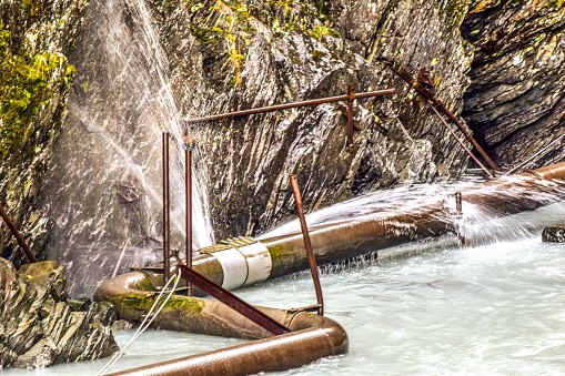 A broken water pipe is observed. The water sprays with force as the water makes its way out the broken pipe.