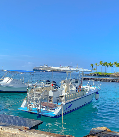 October 14, 2022, Kona, Hawaii.  The Kona dock offers any visitor a stunning view.  Tourists and locals alike often walk by the docks and view the boats harbored there.  Many will opt to take a scenic boat ride in the Pacific Ocean, offering a different view of this tropical area.