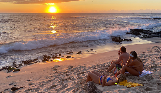 October 14, 2022, Kona, Hawaii.  The sun sets on yet another day in Kona, Hawaii. A family comes to the beach to enjoy the beauty that is on display.