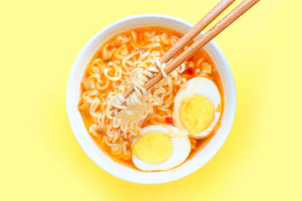 istock Bowl with ramen and egg on yellow background top view, selective focus. 1438805076