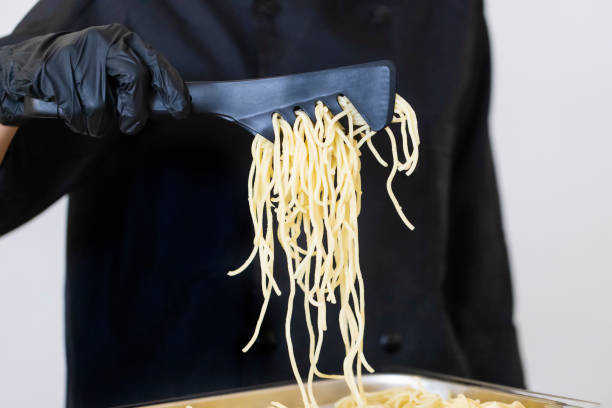 Cook serving pasta with tongs