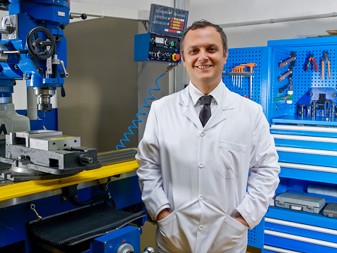 Engineer looking at camera and smiling in factory
