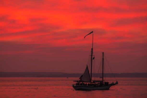 Seattle, USA - Oct 6th, 2022: A vivid sunset over Elliott bay with settle’s tallest ship, The Bay Lady at the Harbor Marina.