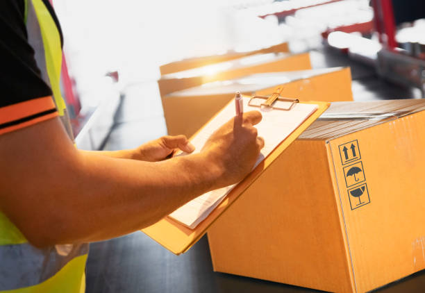 istock Workers Holding Clipboard is Checking Packaging Boxes on Conveyor Belt. Warehouse Inventory Management. Supply Chain. Shipment Boxes Shipping Warehouse Logistics. 1438826129