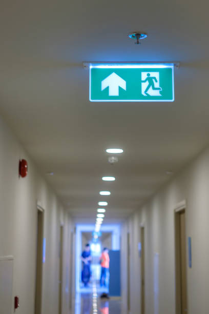 istock Fire Emergency exit sign on the wall background inside building. Safety concept 1438834234