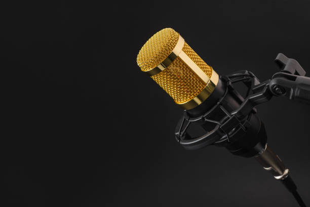 istock Golden studio condenser microphone on a black background. 1438835248