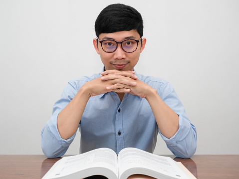 Handsome asian businessman wear glasses confident looking at you sit at the desk