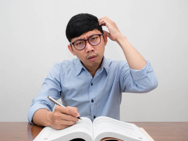 istock Asian businessman sit at working table feels confused scratch head gesture doubt 1438835980