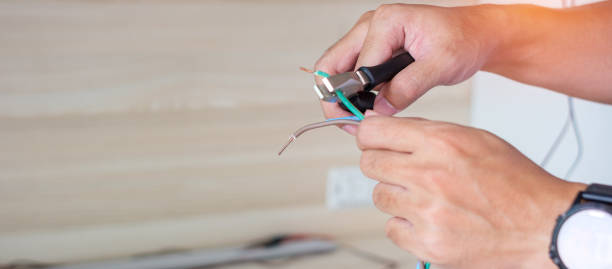 전기 기술자는 펜치, 소켓 플러그 용 배선 케이블 설치로 전선을 절단합니다. 주택 및 아파트 개념의 고정, 개조, 수리, 서비스 및 개발 - maintenance engineer home improvement men manual worker 뉴스 사진 이미지