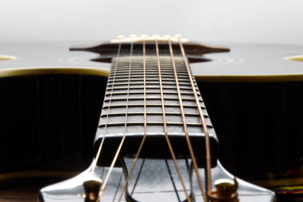 istock Acoustic black guitar isolated on white background, focus on fretboard 1438841577