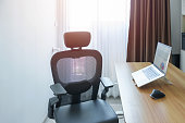 Ergonomic chair and Adjustable table with laptop computer in modern workplace. Good posture to avoid Office syndrome, Back Pain, shoulder ache, fibromyalgia and Neck pain