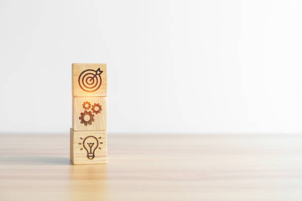 istock dartboard above Gear and Lightbulb icon block on desk. business planning process, goal, strategy, target, mission, action, objective, teamwork and idea concept 1438848085