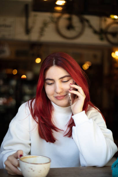 istock Redhead girl is speaking on mobile phone. 1438848608