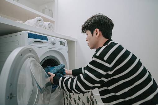 Chinese Gay man doing laundry at home