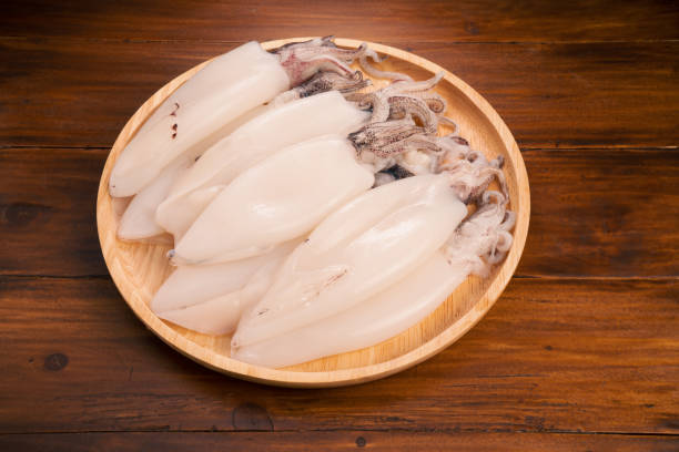 Fresh Squid in wooden plate on wooden background, Fresh Splendid Squid on wooden plate.