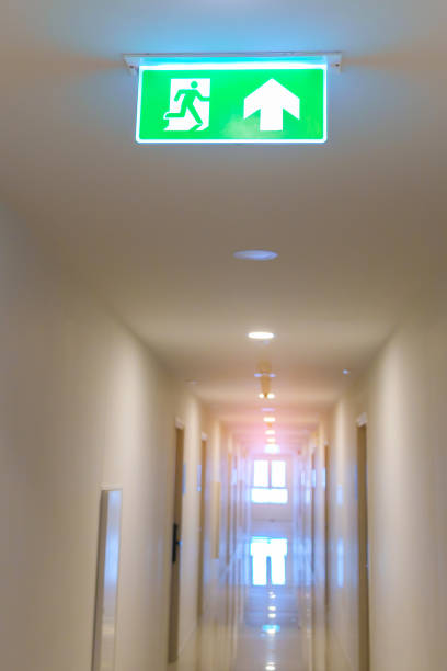 istock Fire Emergency exit sign on the wall background inside building. Safety concept 1438853127