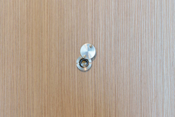 Lens peephole on wood door in apartment room. Security concept Lens peephole on wood door in apartment room. Security concept peep hole stock pictures, royalty-free photos & images