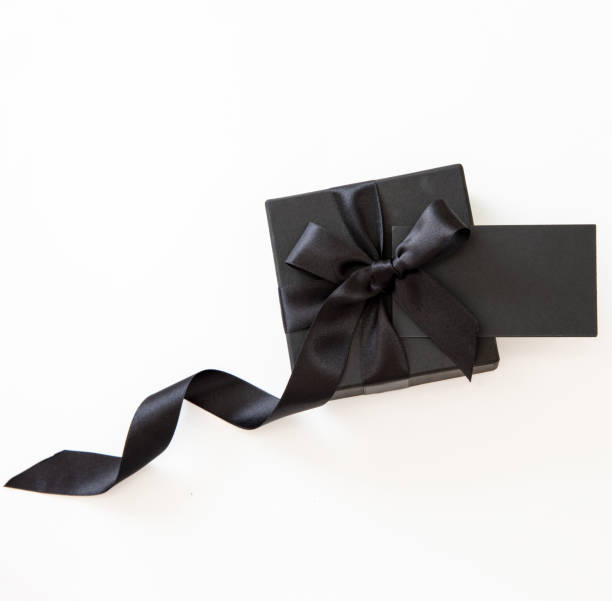 istock Black Friday Sale. Gift box with black ribbon and empty card isolated on white 1438854820