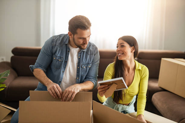 istock Smiling couple unpaking boxes in new home 1438854921
