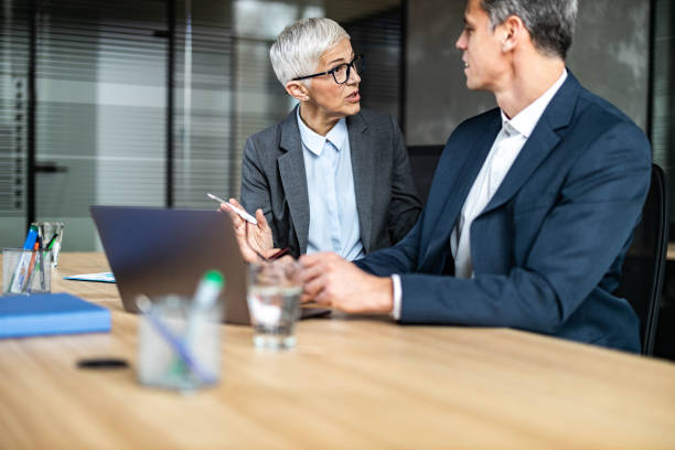 istock Business colleagues talking while working on laptop in the office. 1438859822
