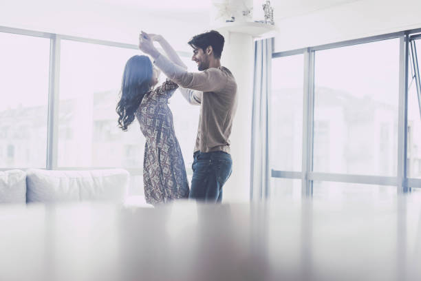 istock Young happy couple talking and dancing at home. 1438859994